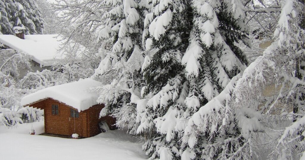 Gartenhütte im Winter unter dicker Schneedecke