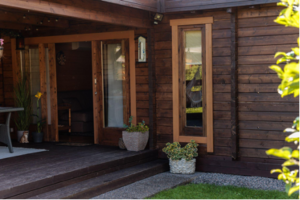 Ansicht des Eingangsbereichs und des Fensters eines Gartenhauses mit Sauna